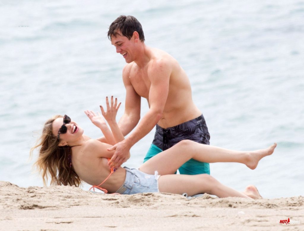 Halston Sage playing with guy at the beach